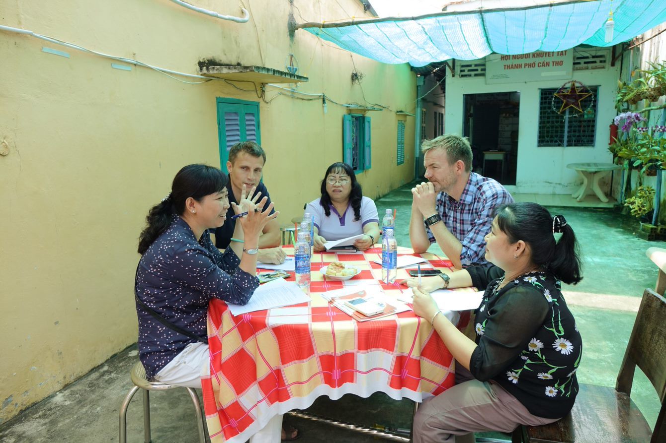 Andersen i dialog med fire personer rundt et bord i Vietnam