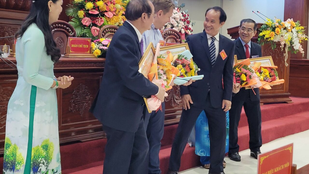 Landdirektør for Misjonsalliansen i Vietnam, Jan Schrøder, får utdelt blomster og plakett for jobben som er gjort i Tiền Giang over mange år.